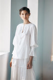 Model wearing the Lilli Blouse in white. 